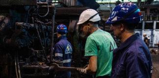 Operai lavorano in fabbrica di acciaio