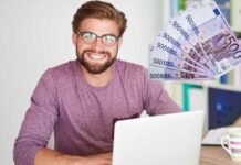 uomo felice al pc e banconote da 500 euro