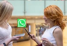WhatsApp, il trucco per chattare senza scambio di numeri di telefono: pazzesco! ragazze con smartphone e simbolo whatsapp