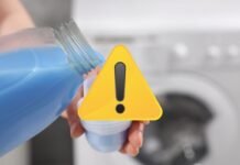 segnale di pericolo e mano che versa detersivo di colore blu