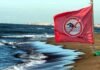spiaggia di sabbia con bandiera divieto di balneazione