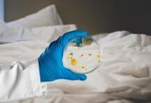 Nemmeno immagini quello che si nasconde tra le lenzuola: ti spiego come lavarle, per non correre rischi lenzuola e mano che mantiene vetrino con batteri