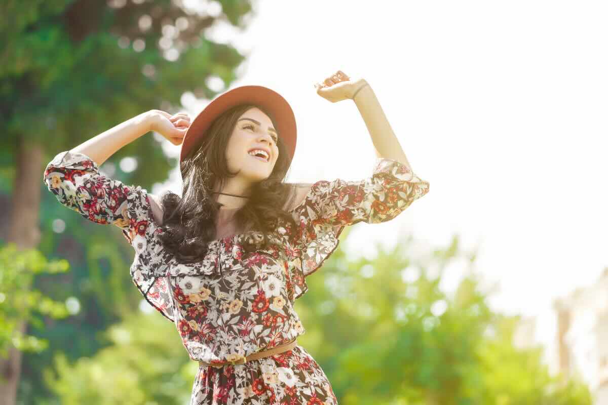 donna felice con cappello e vestito a fiori 