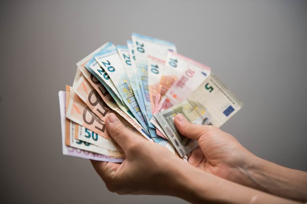 mani che tengono varie banconote in euro 