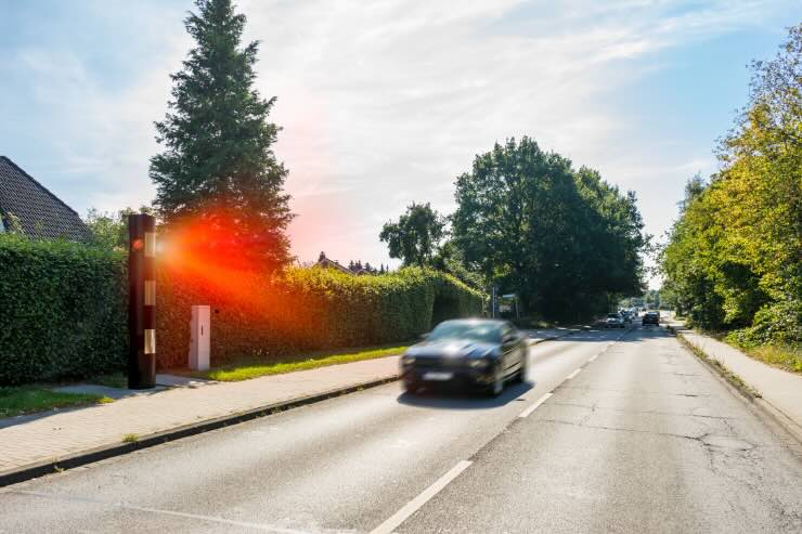 auto che cammina e autovelox con fascio di luce rossa