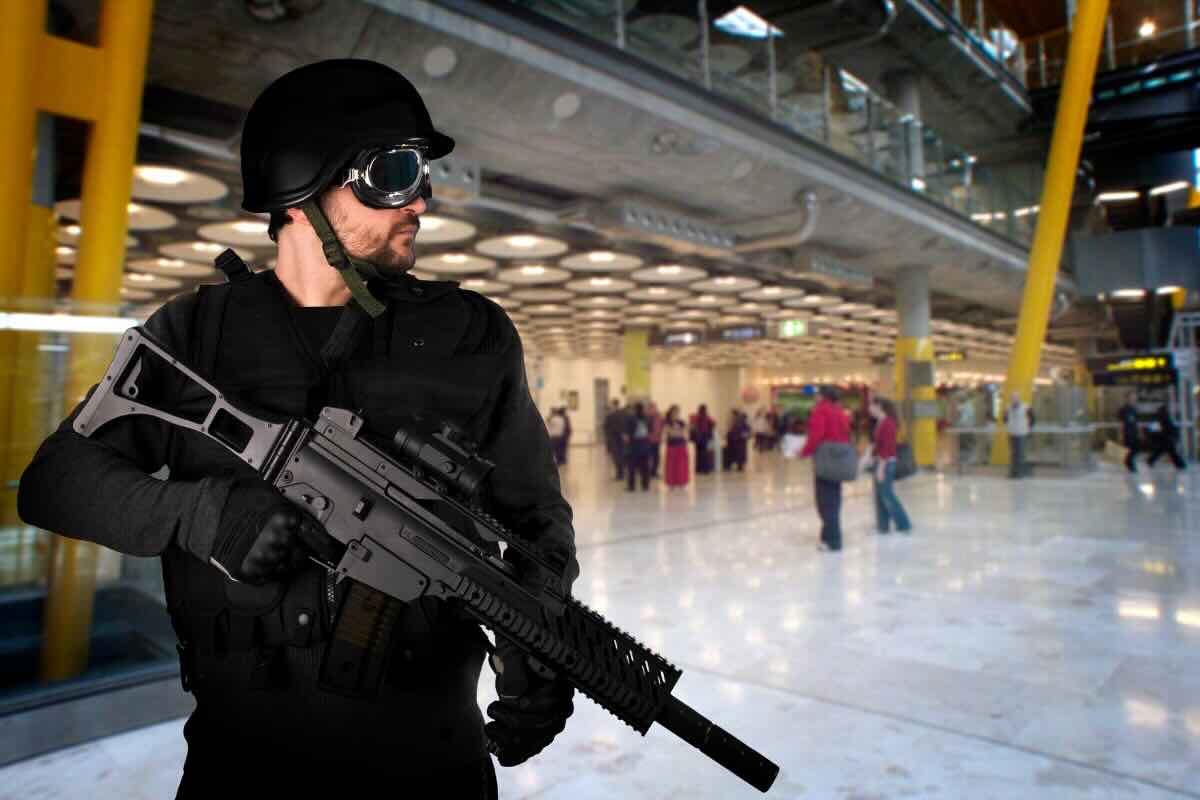 uomo con fucile ed elmetto in aeroporto