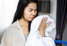 donna annusa asciugamano con cattivo odore