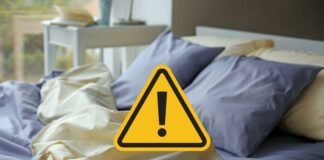 letto sfatto e segnale di pericolo giallo