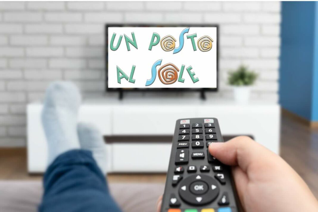 braccio con telecomando in mano e tv con logo un posto al sole