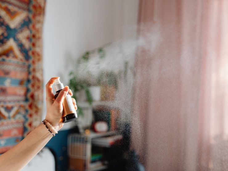 donna che spruzza un profumo nell'aria