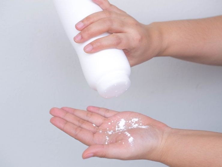 persona che si versa del borotalco sulla mano