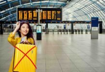 donna in aeroporto con bagaglio giallo