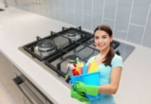 piano cottura e donna con prodotti per la pulizia