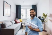 Come rendere più grande un soggiorno piccolo: questi trucchi saranno una vera svolta soggiorno e uomo sorridente con carte in mano