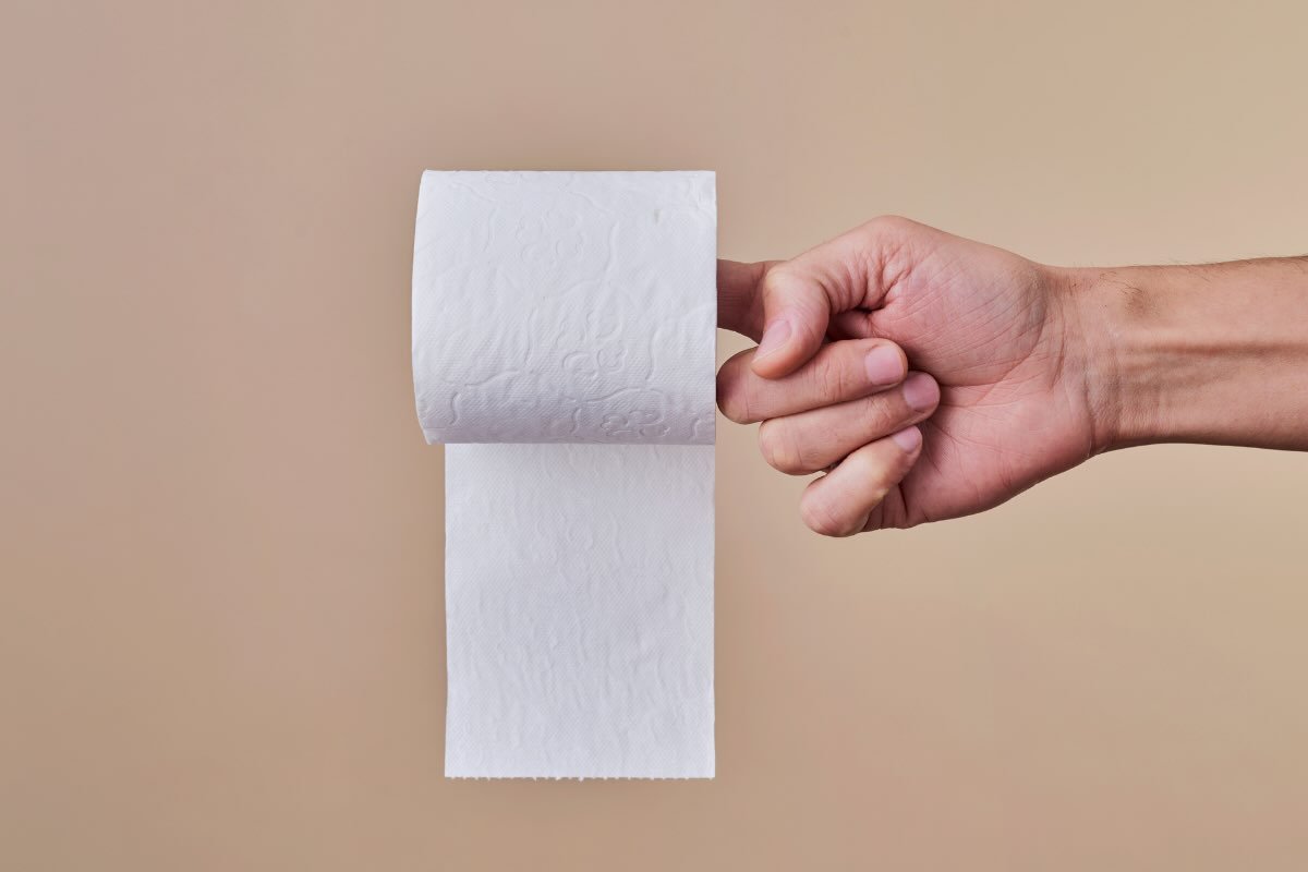 dita della mano con carta igienica
