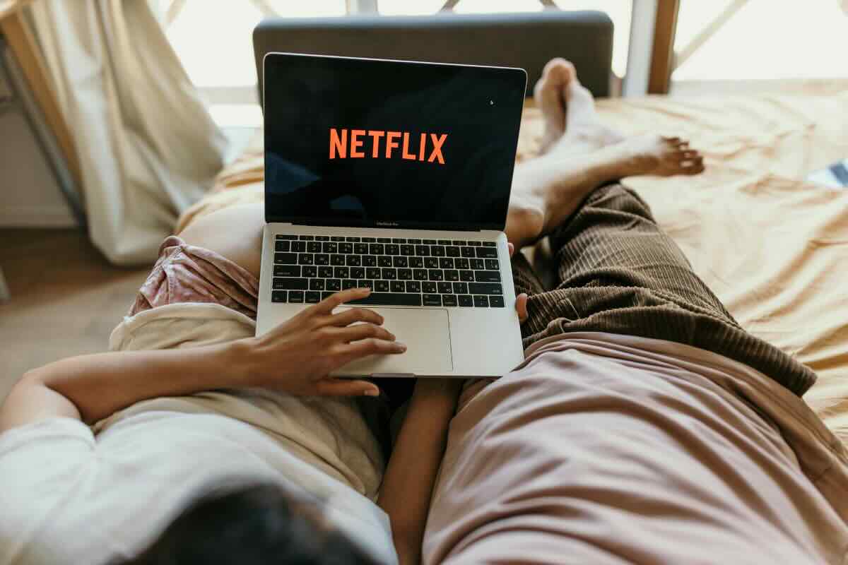 uomo e donna sdraiati che guardano netflix al pc