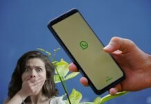 mano che tiene smartphone con whatsapp e donna con mano in bocca