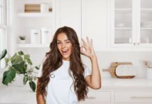 donna che fa ok e cucina bianca alle spalle