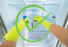 spunta verde su mani che puliscono il frigorifero