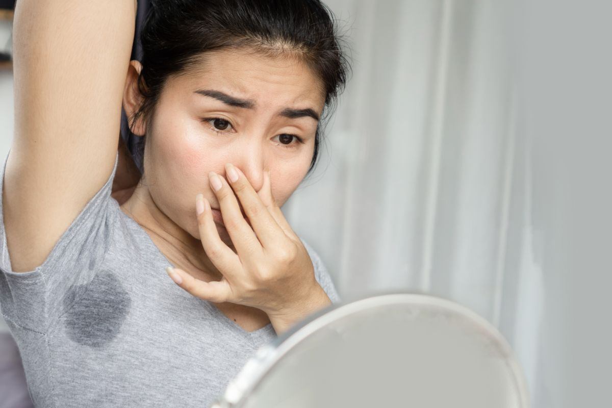 donna che si tappa il naso per la puzza di sudore
