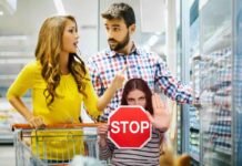 coppia al supermercato con carrello e donna con segnale stop
