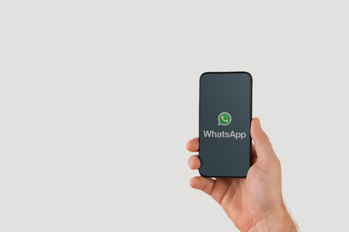 mano con smartphone con whatsapp