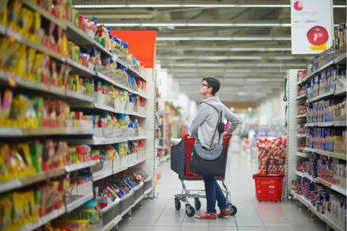 uomo fra gli scaffali del supermercato