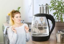 donna disgustata e bollitore elettrico con acqua