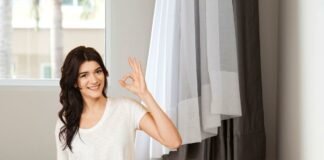 donna che fa ok e soggiorno con tende