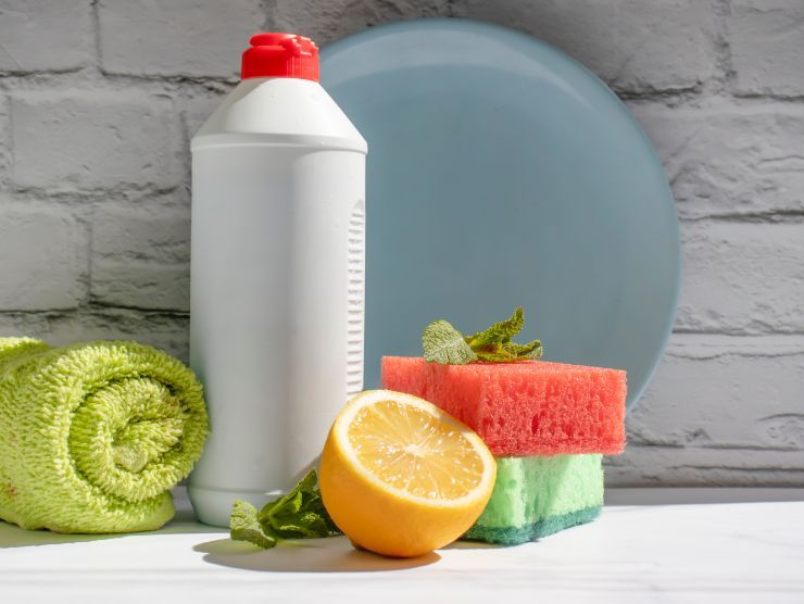 detersivo per piatti, spugnette e limone