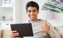 uomo felice al tablet e banconote di euro