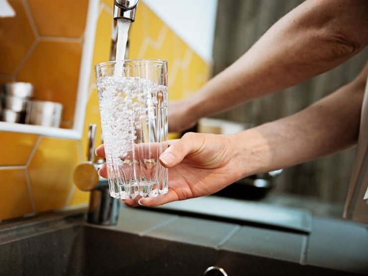 bicchiere d'acqua riempito dal rubinetto