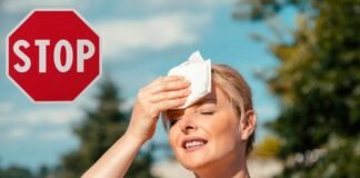 donna che si asciuga sudore per il caldo e segnale stop