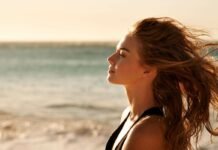 donna di profilo in riva al mare al tramonto