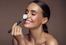 donna sorridente che si passa pennello da trucco sul naso