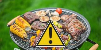 barbecue con carne e segnale di pericolo