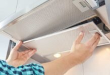 Cappa aspirante, 4 consigli per tenerla sempre igienizzata anche in estate: ci vorrà un attimo persona che smonta cappa per la pulizia
