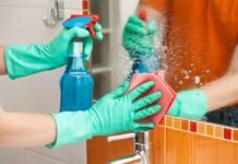 persona che pulisce specchio con spray e pezza