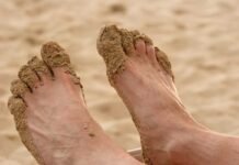 piedi di uomo pieni di sabbia