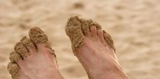 piedi di uomo pieni di sabbia