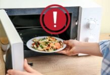 simbolo di pericolo e persona che mette del cibo nel microonde