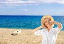 donna con cappello, sabbia e mare