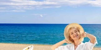 donna con cappello, sabbia e mare