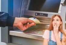 mano che preleva soldi e donna preoccupata