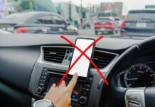 Addio al cellulare in auto, scatta il divieto assoluto: cosa cambia smartphone in auto con x rossa sopra