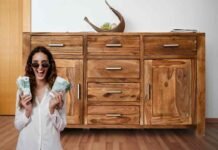 credenza in legno, donna con euro e occhiali