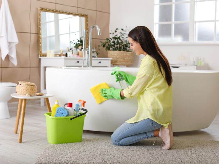 donna che pulisce vasca da bagno