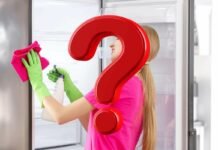 grande punto interrogativo e come sfondo una donna che pulisce frigo