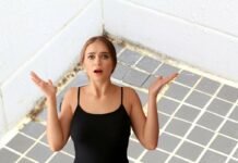 donna preoccupata e bagno con muffa