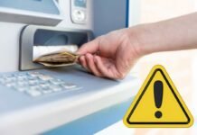 Prelievi bancomat, fai attenzione: adesso il rischio è altissimo mano che preleva e simbolo attenzione
